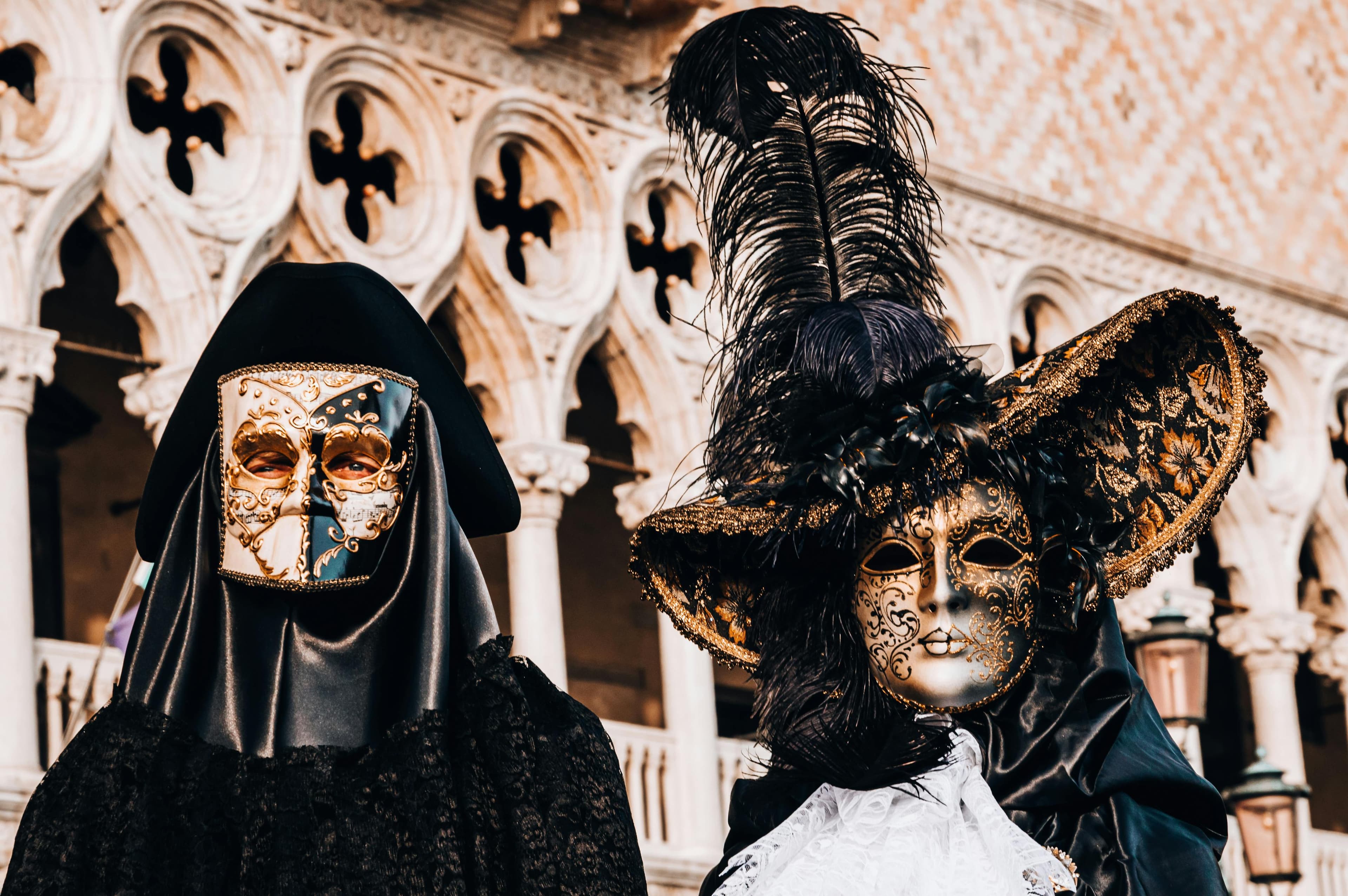 Two masked figures in etxravagant dress attend a ball.