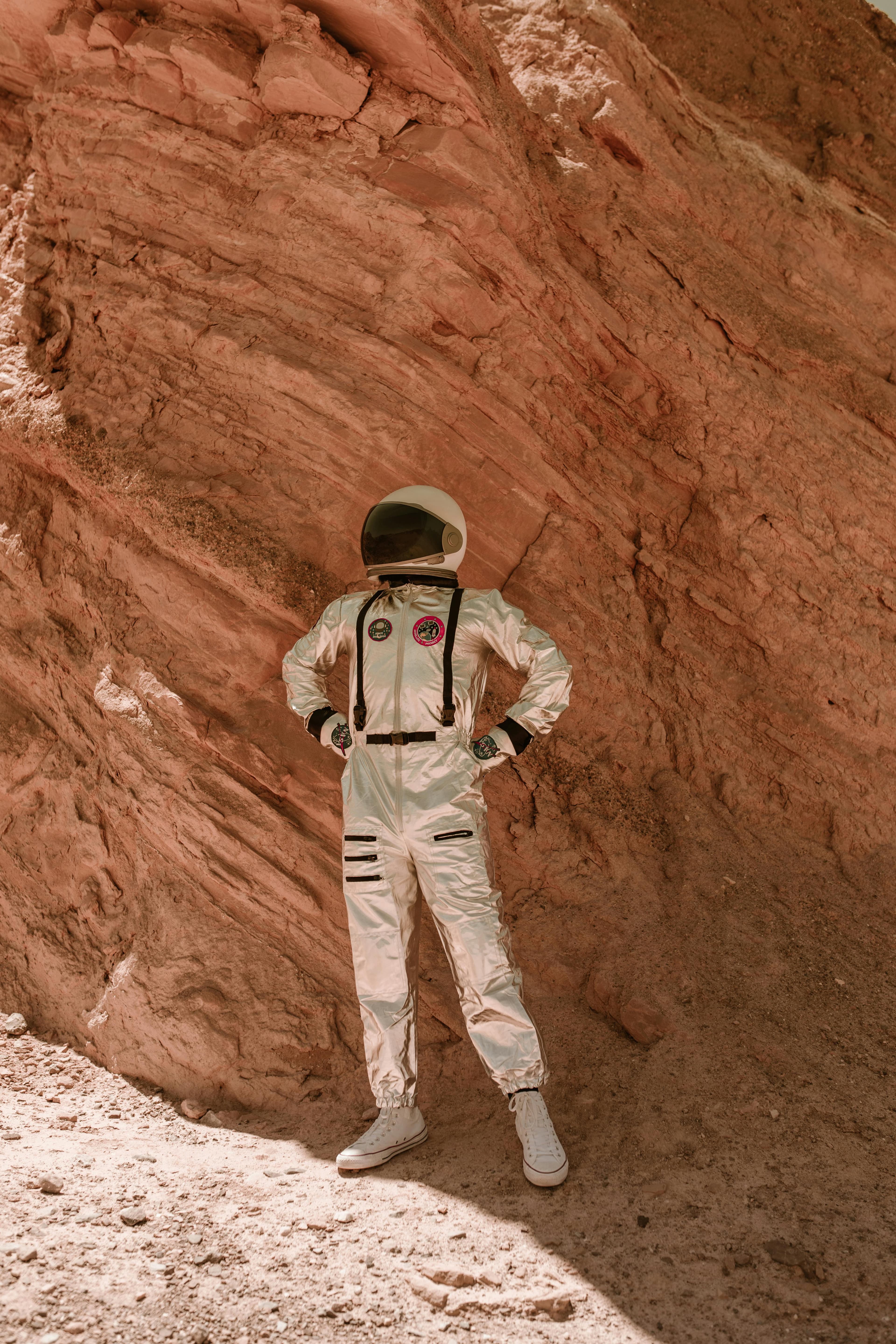 Spaceman in a spacesuit inside of a canyon.